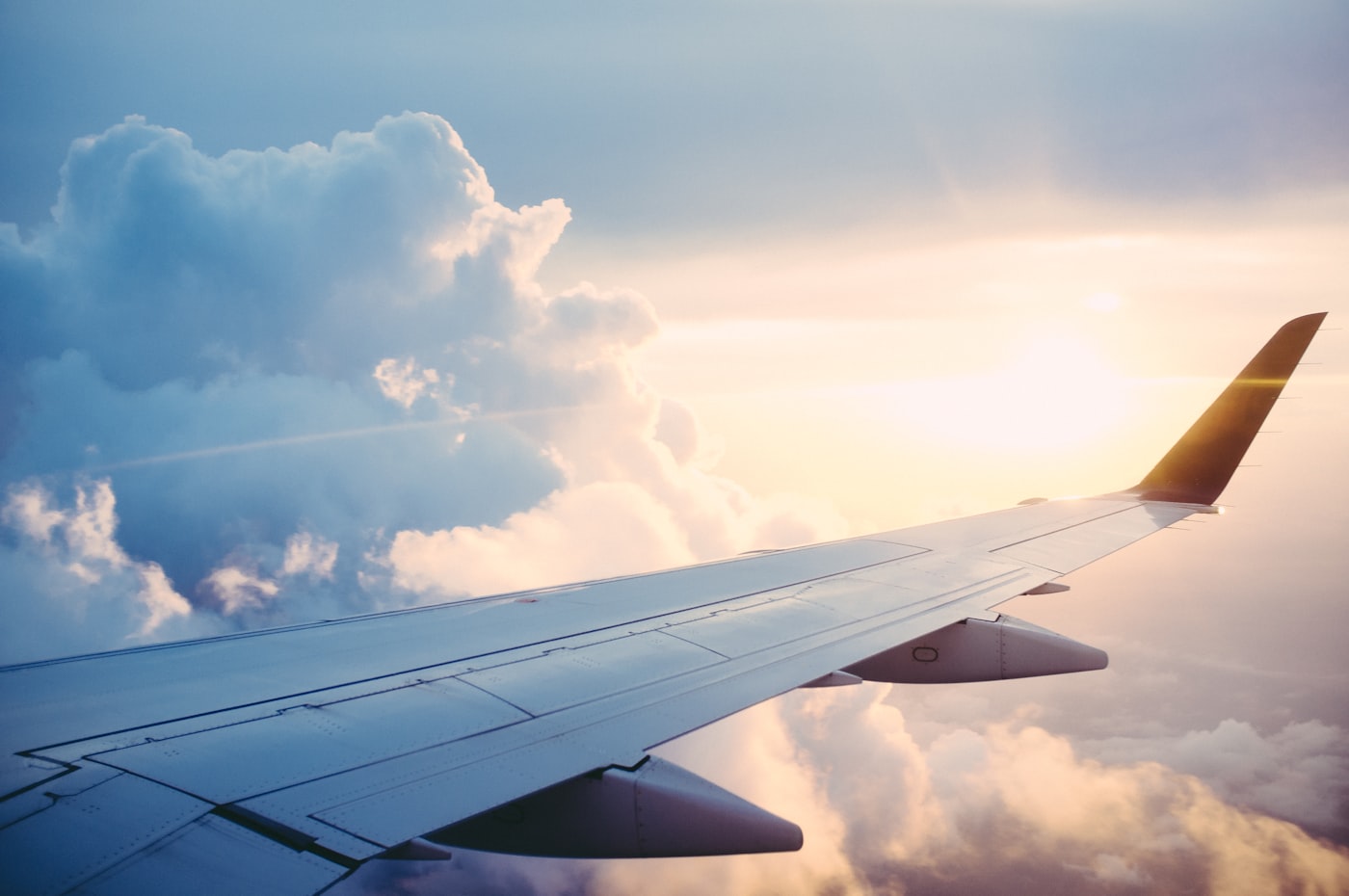Aeroplane wing above the clouds at sunrise